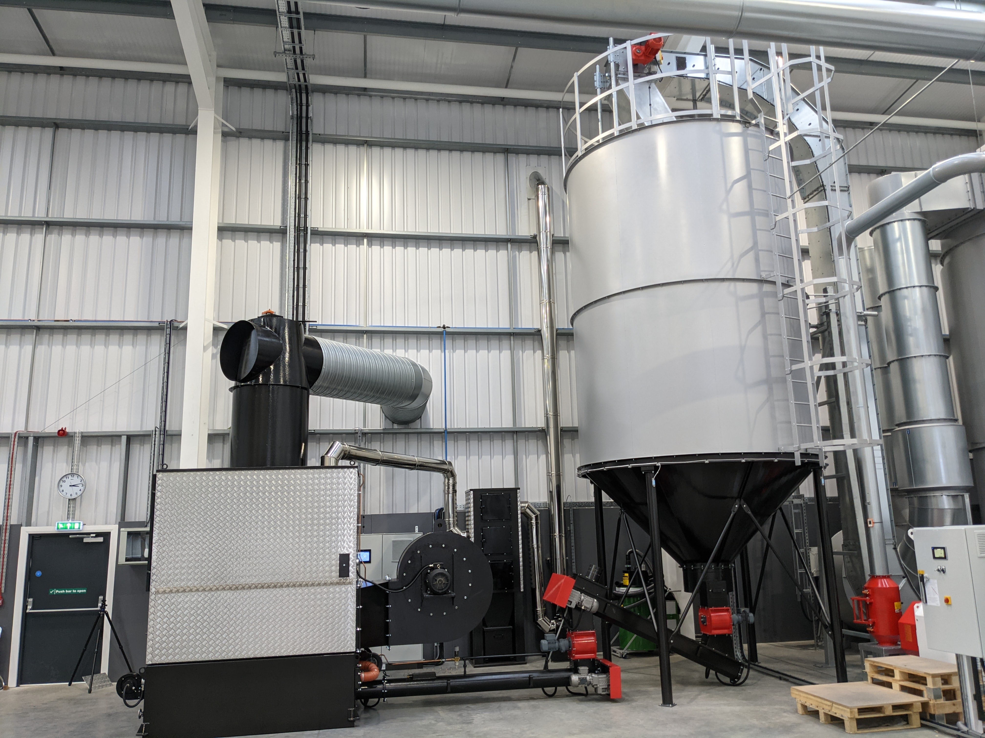 WA 300 warm air heater with C28 silo fed by drag conveyor in panel processing factory