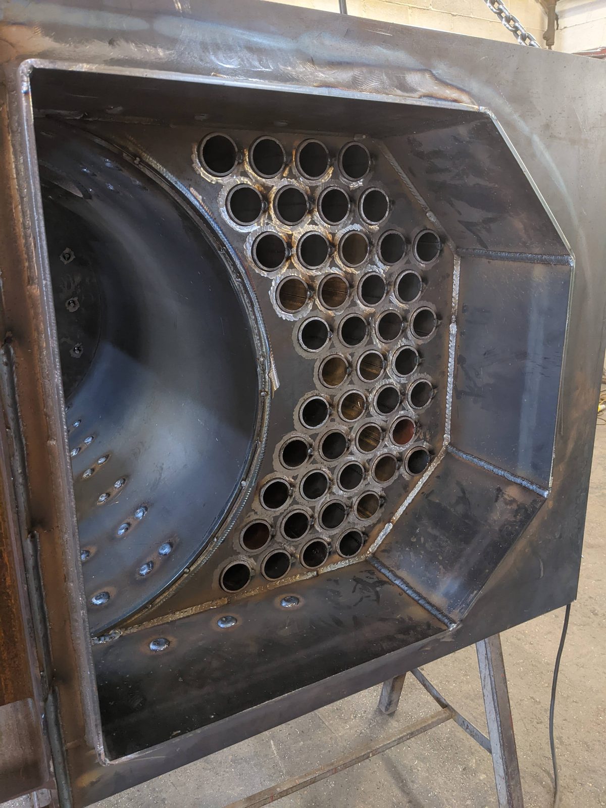 Factory photograph of a Ranheat MSU 300 biomass boiler near the end of production, showing the welded fire-tube plate and horseshoe combustion chamber