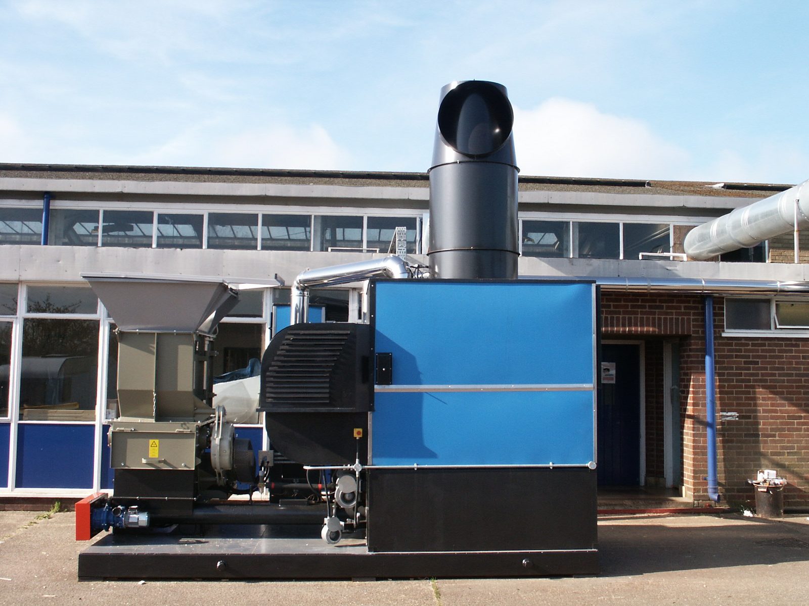 Front elevation of Ranheat WA 300 warm air heater with hogger loader and flue outlet at A&J Sectional Building