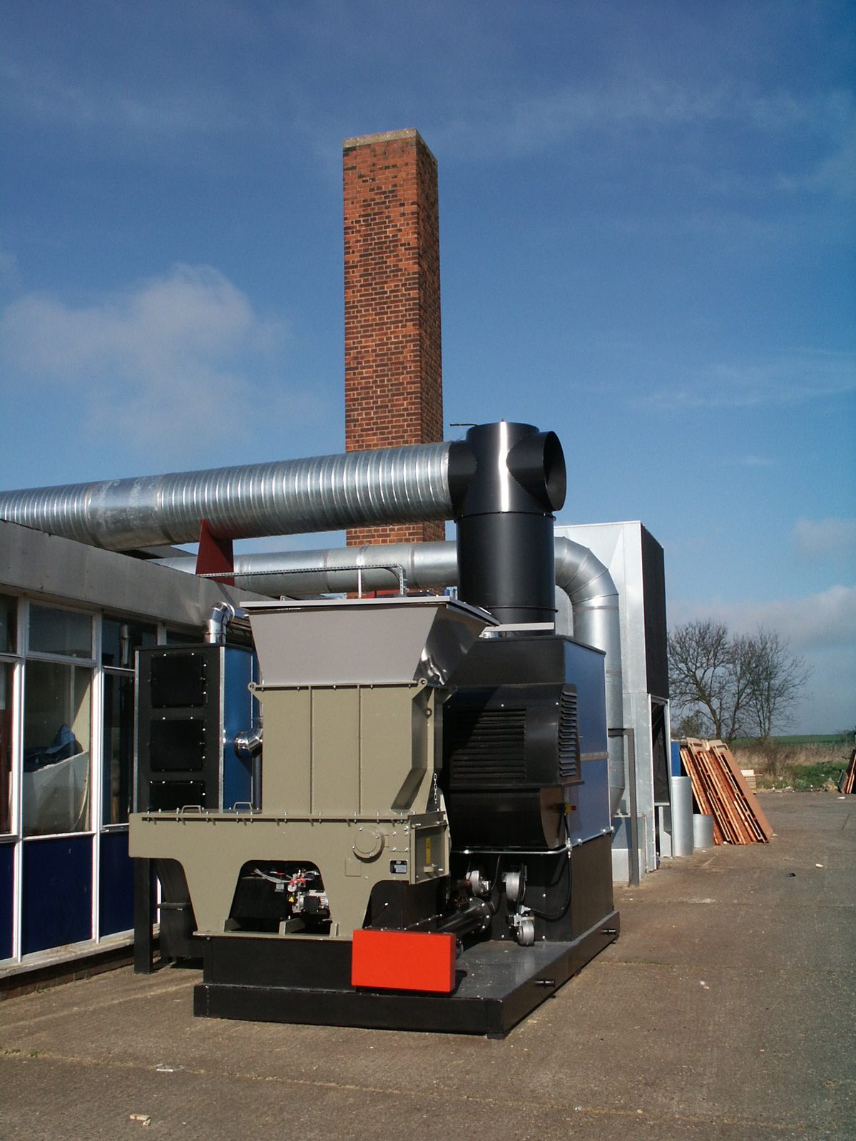 Ranheat WA 300 300kW warm air heater with hogger loader fuel system and brick chimney at A&J Sectional Building